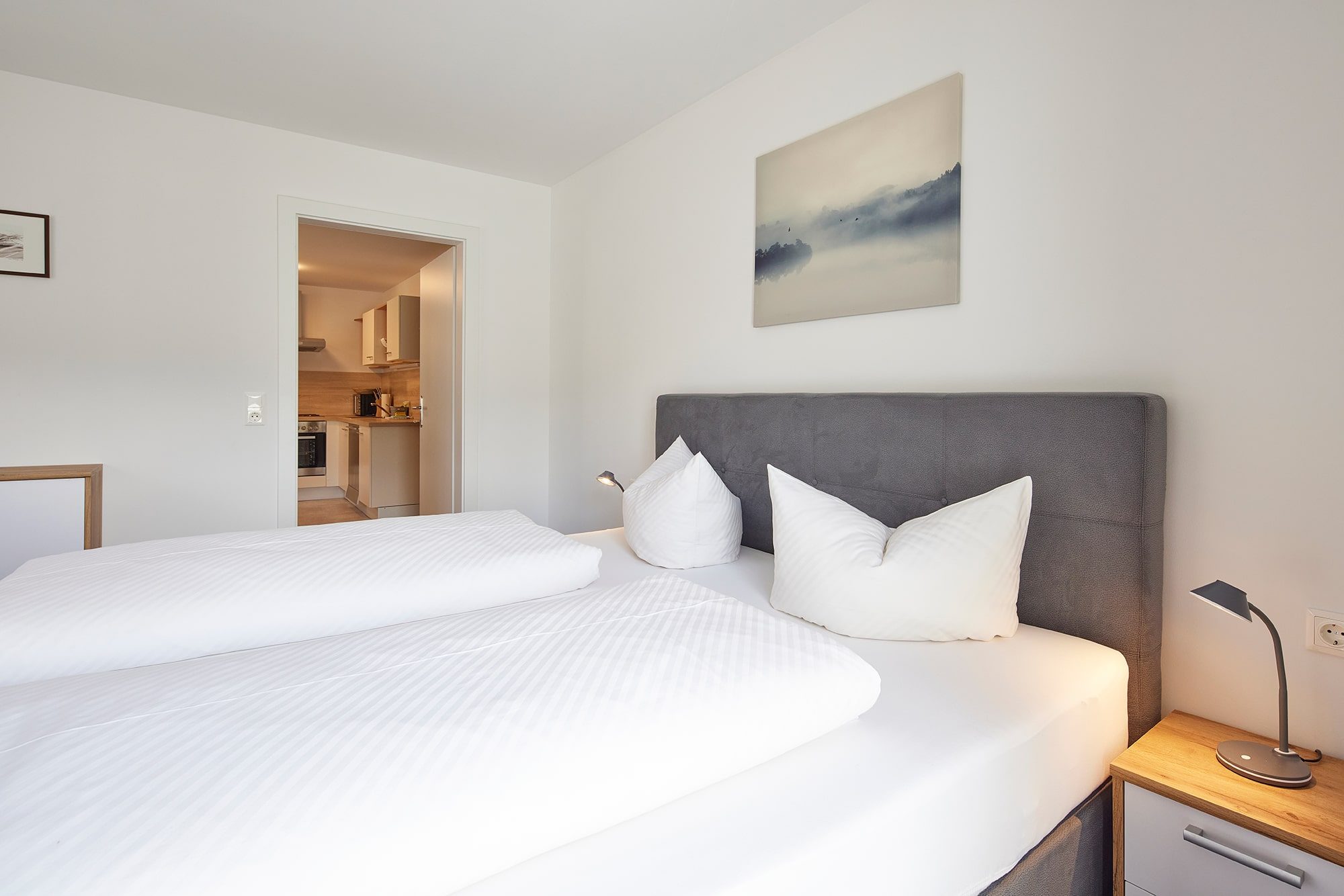 Doppelbett im Appartement Zwoa mit Blick zur Küche